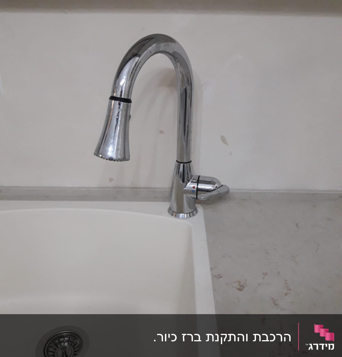 ברז נירוסטה מעל כיור לבן במטבח